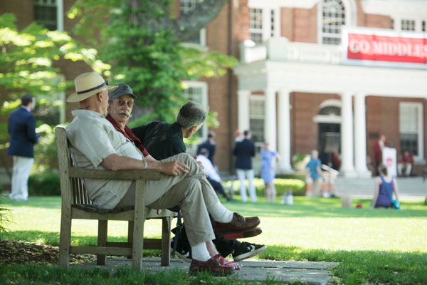 Men sitting in a bench on campus